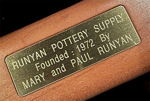 brass plaque that reads Runyan Pottery Supply founded: 1972 by Mary and Paul Runyan
